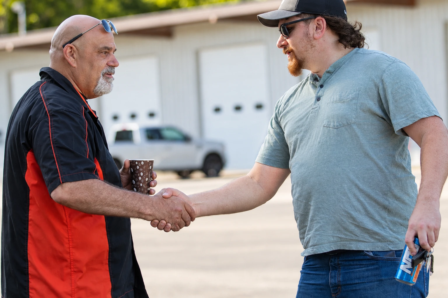Two people shaking hands outside the shop.